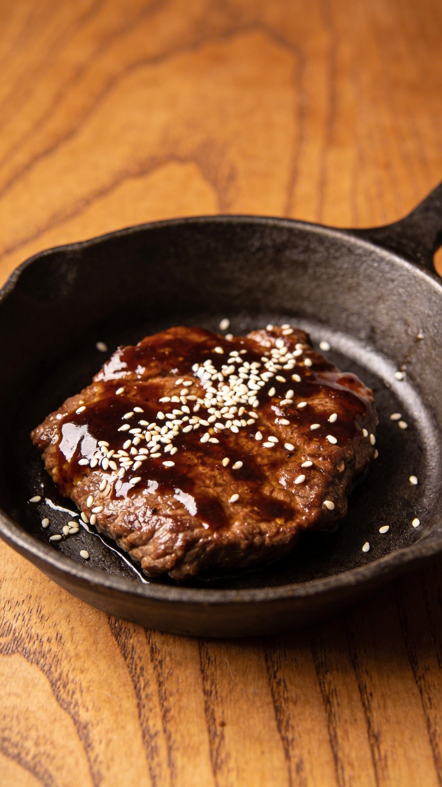 [RECIPE 1] single skillet glaze-coated beef with sesame on wooden table